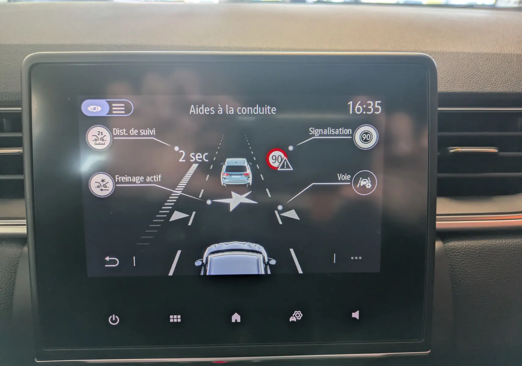 Écran tactile 7 pouces du Renault Captur gris Highland montrant les aides à la conduite avec distance de suivi et reconnaissance panneaux.