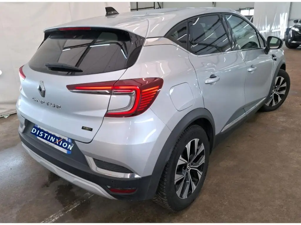 Renault Captur II Techno gris Highland vu de profil côté gauche en intérieur avec jantes alliage bicolores.