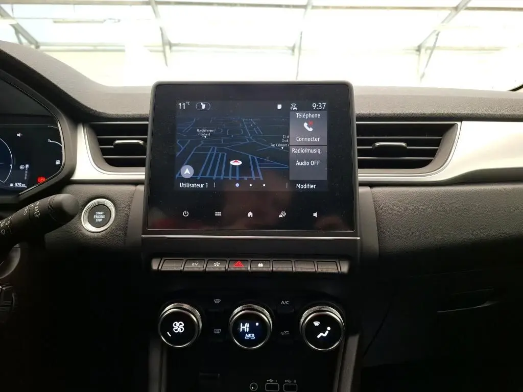 Coffre ouvert vu de l'arrière d'un Renault Captur gris Highland 2023, montrant l'espace de chargement vide.