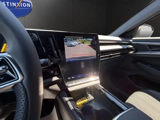 Vue intérieure côté conducteur du tableau de bord noir du Renault Austral 2025 avec écran tactile affichant la caméra de recul.