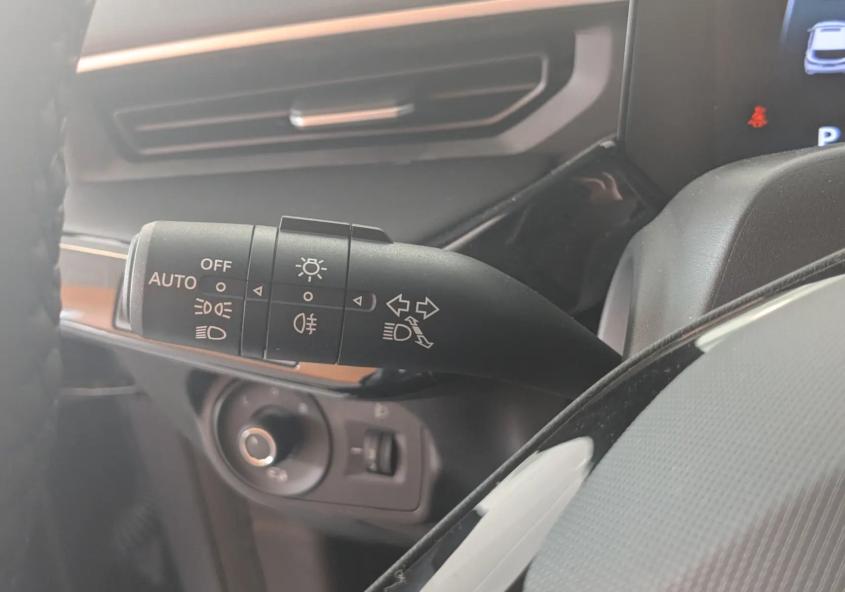 Gros plan sur la commande des feux et clignotants du MG3 1.5L Hybrid+ 195CH Luxury, intérieur gris noir.