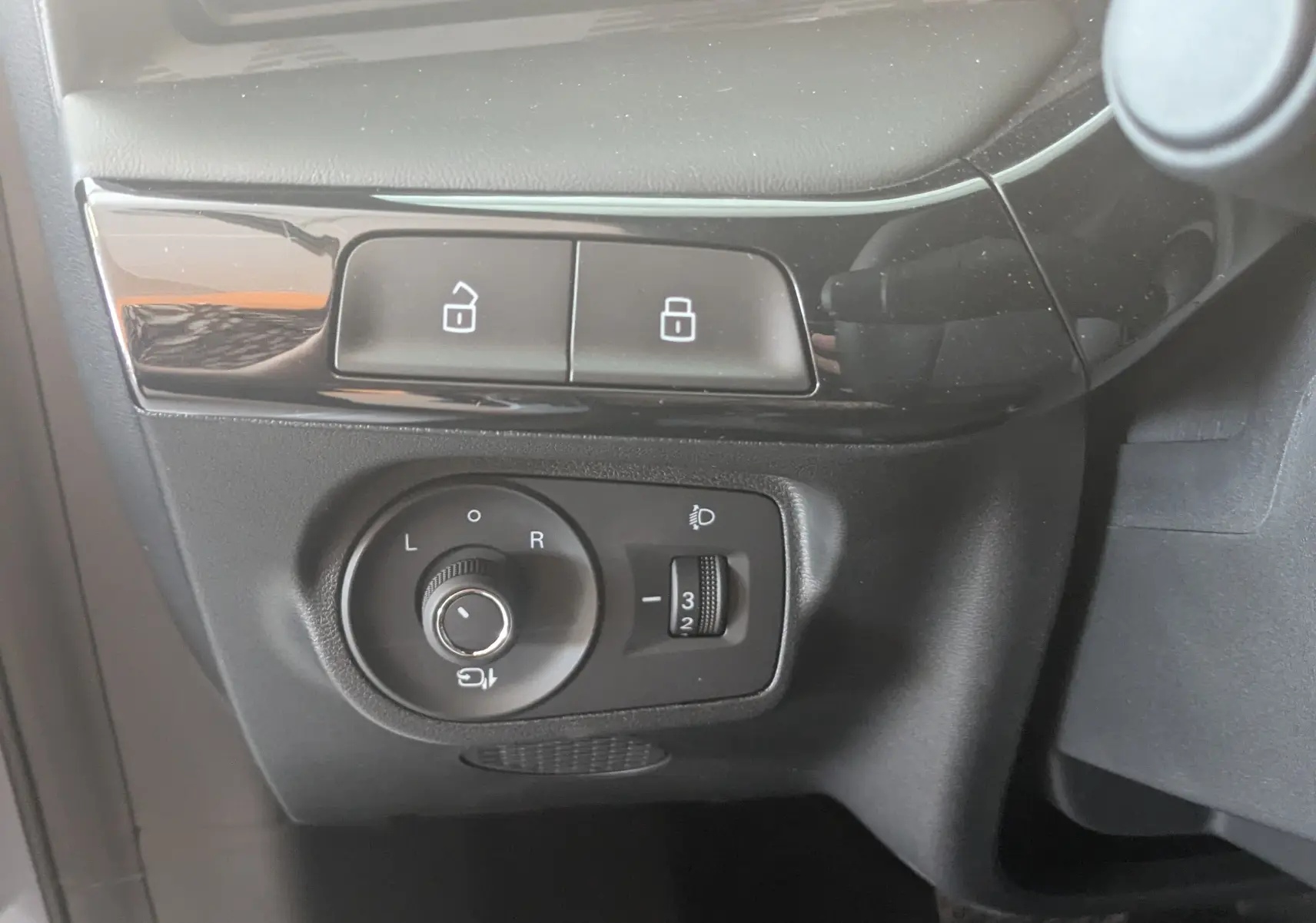 Gros plan sur les commandes de réglage des rétroviseurs et verrouillage, intérieur noir du MG MOTOR MG3 2026.