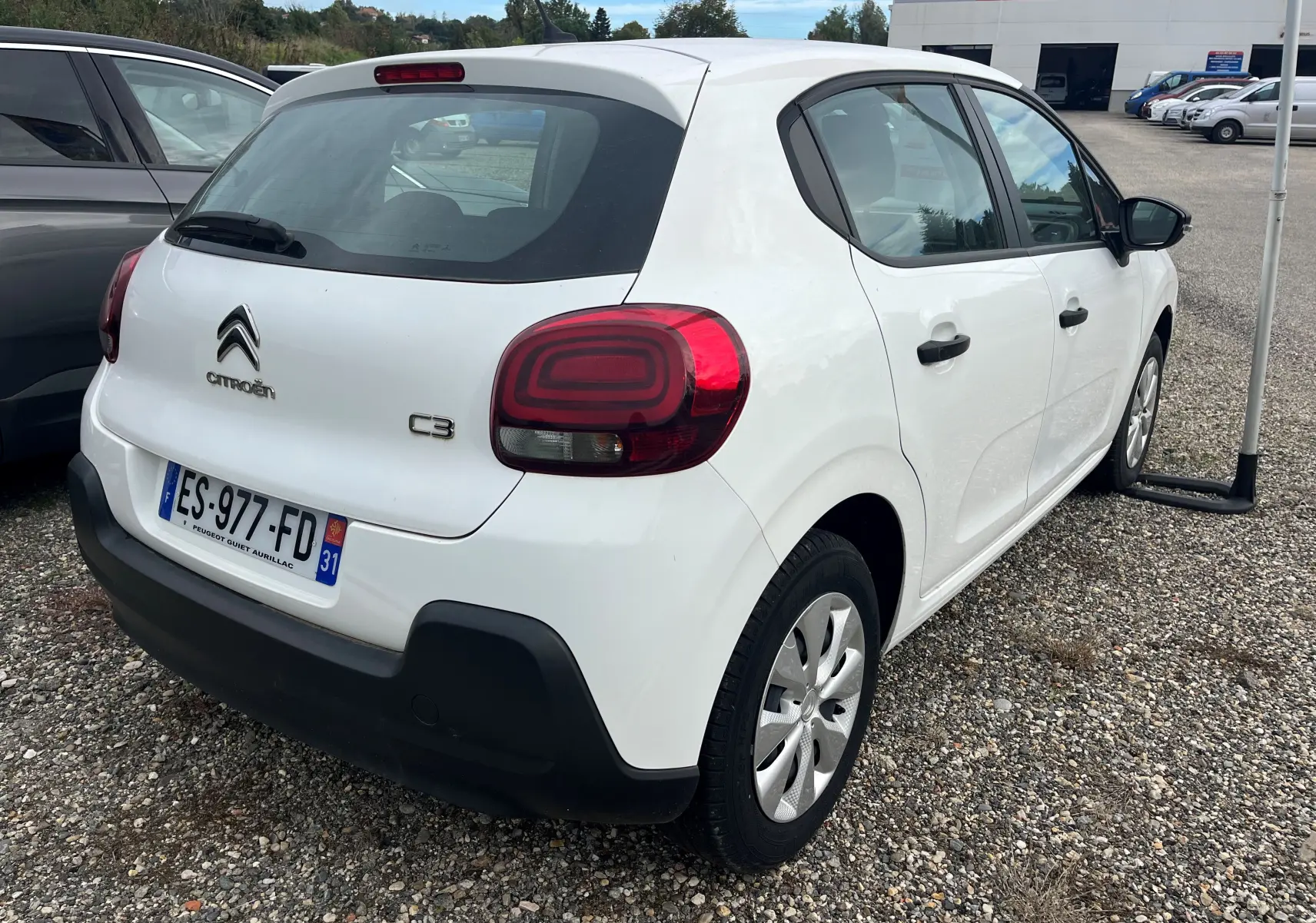 Vue 3/4 arrière droite d'une Citroën C3 blanche de 2017, avec hayon et feux arrière distinctifs rouges.