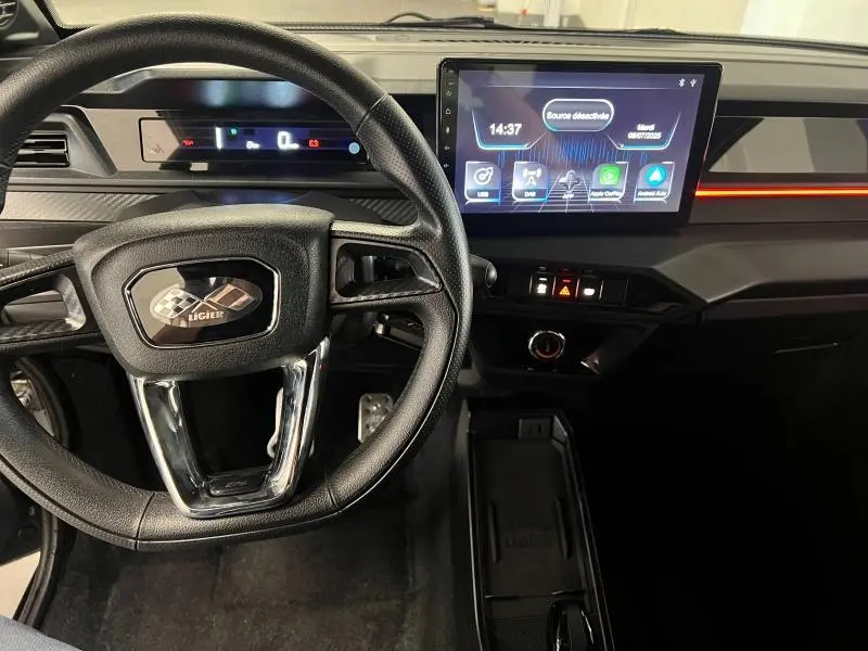 Vue intérieure du tableau de bord et volant du Ligier JS50 Sport Ultimate E5+ gris 2025 avec écran tactile central.