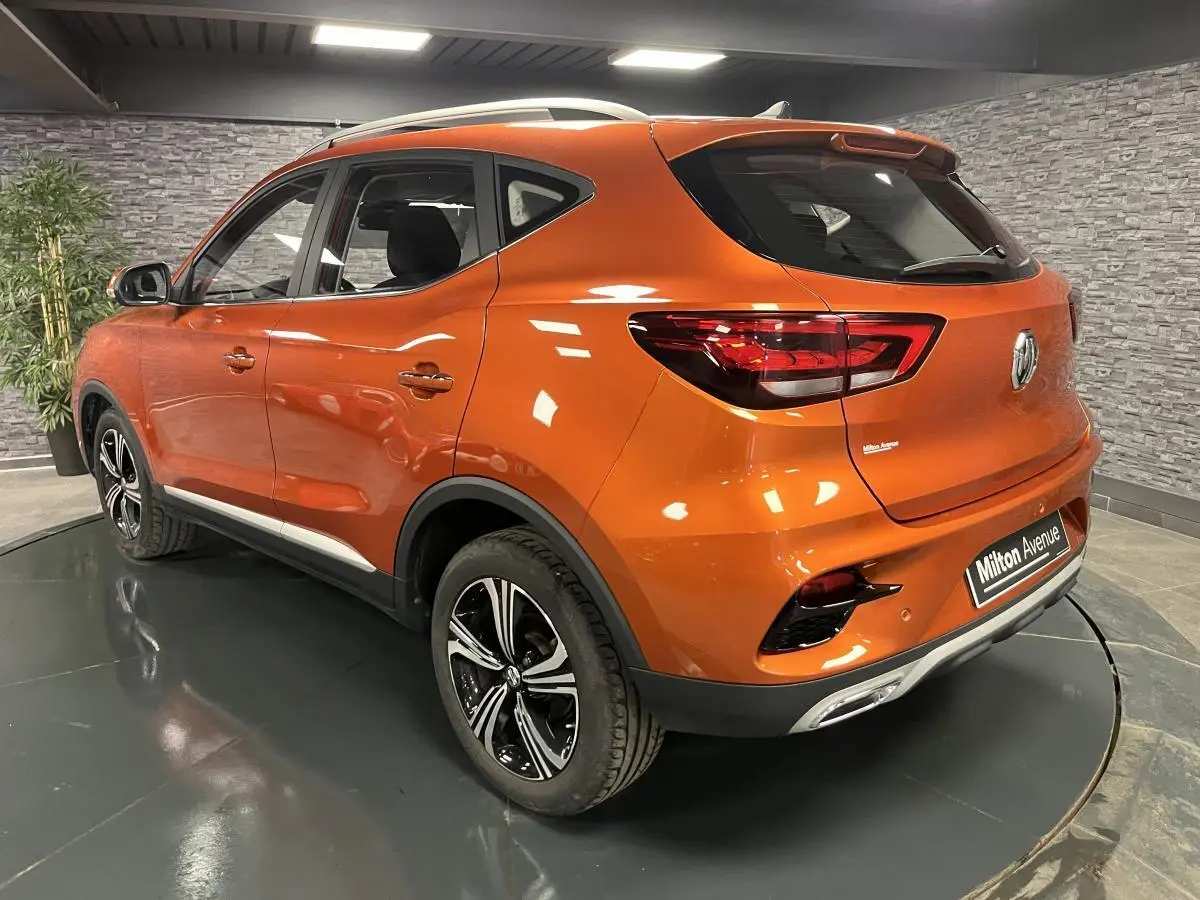 Vue 3/4 arrière droite d'un MG ZS orange métallisé 2022 avec jantes alliage 17 pouces et feux arrière LED.