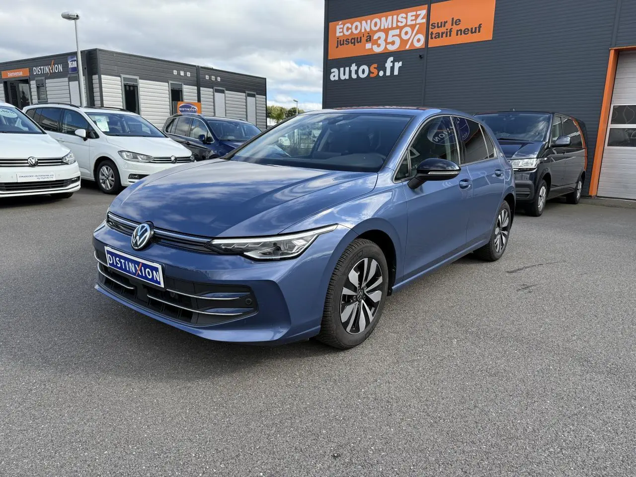 Volkswagen Golf 2024 bleu anémone métallisé vue 3/4 avant droit avec jantes alliage et vitres surteintées.