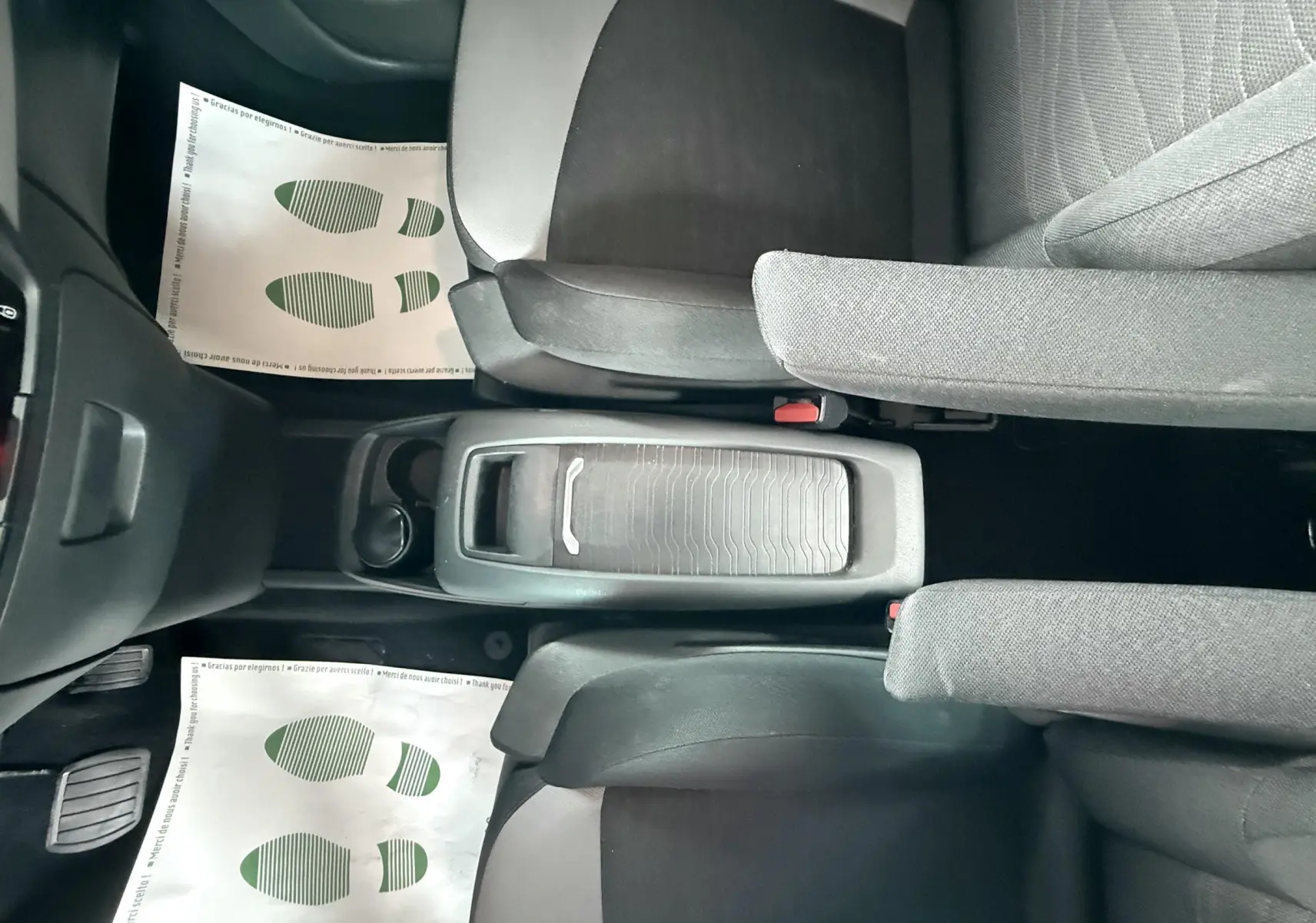 Vue plongeante sur la console centrale et sièges avant gris foncé du Citroën C4 Picasso blanc de 2014.