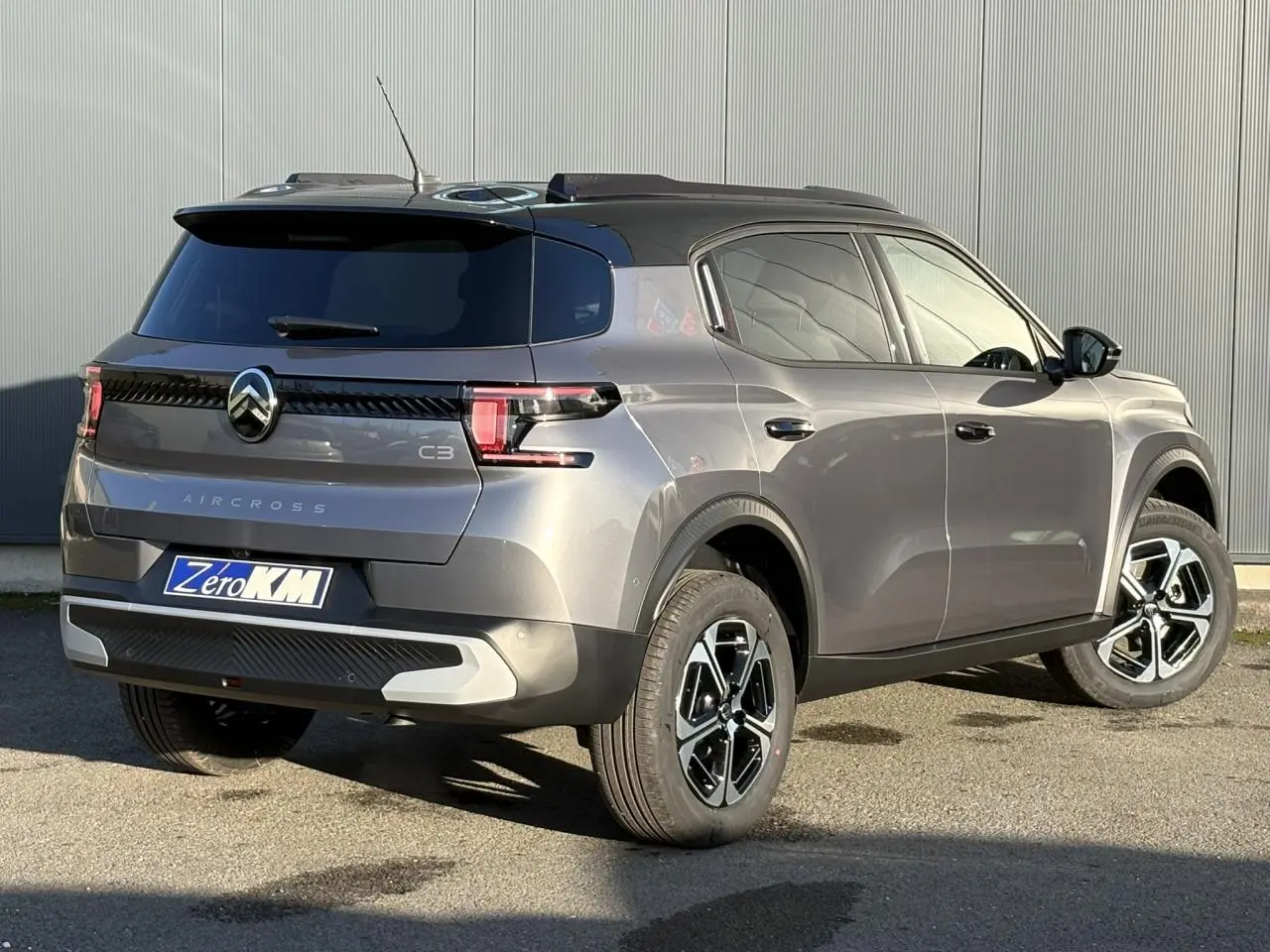 Vue 3/4 arrière droite du Citroën C3 Aircross gris Mercury avec toit noir et jantes alliage 17 pouces.