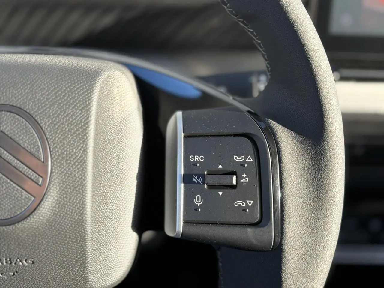 Gros plan sur les commandes multifonctions du volant noir du Citroën C3 Aircross Hybrid 2025.