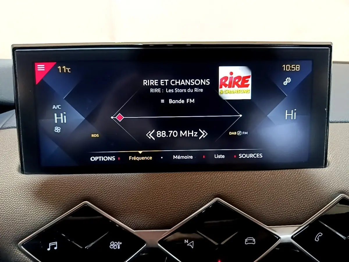 Écran tactile central du tableau de bord du DS3 Crossback bleu, affichant la radio FM et la climatisation à 11°C.
