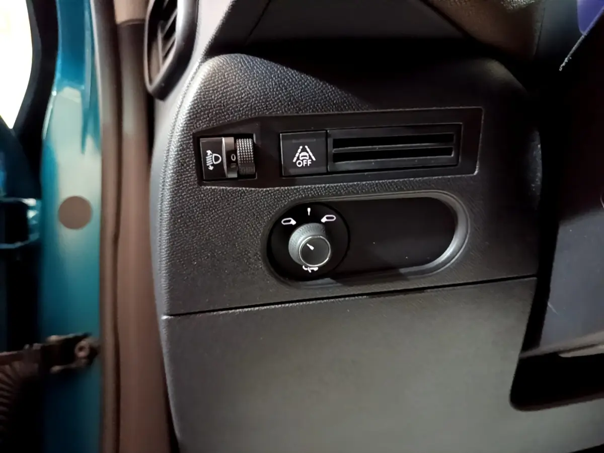 Vue rapprochée du panneau de commandes côté gauche du tableau de bord d'un DS3 Crossback bleu, avec réglage phares et assistance conduite.