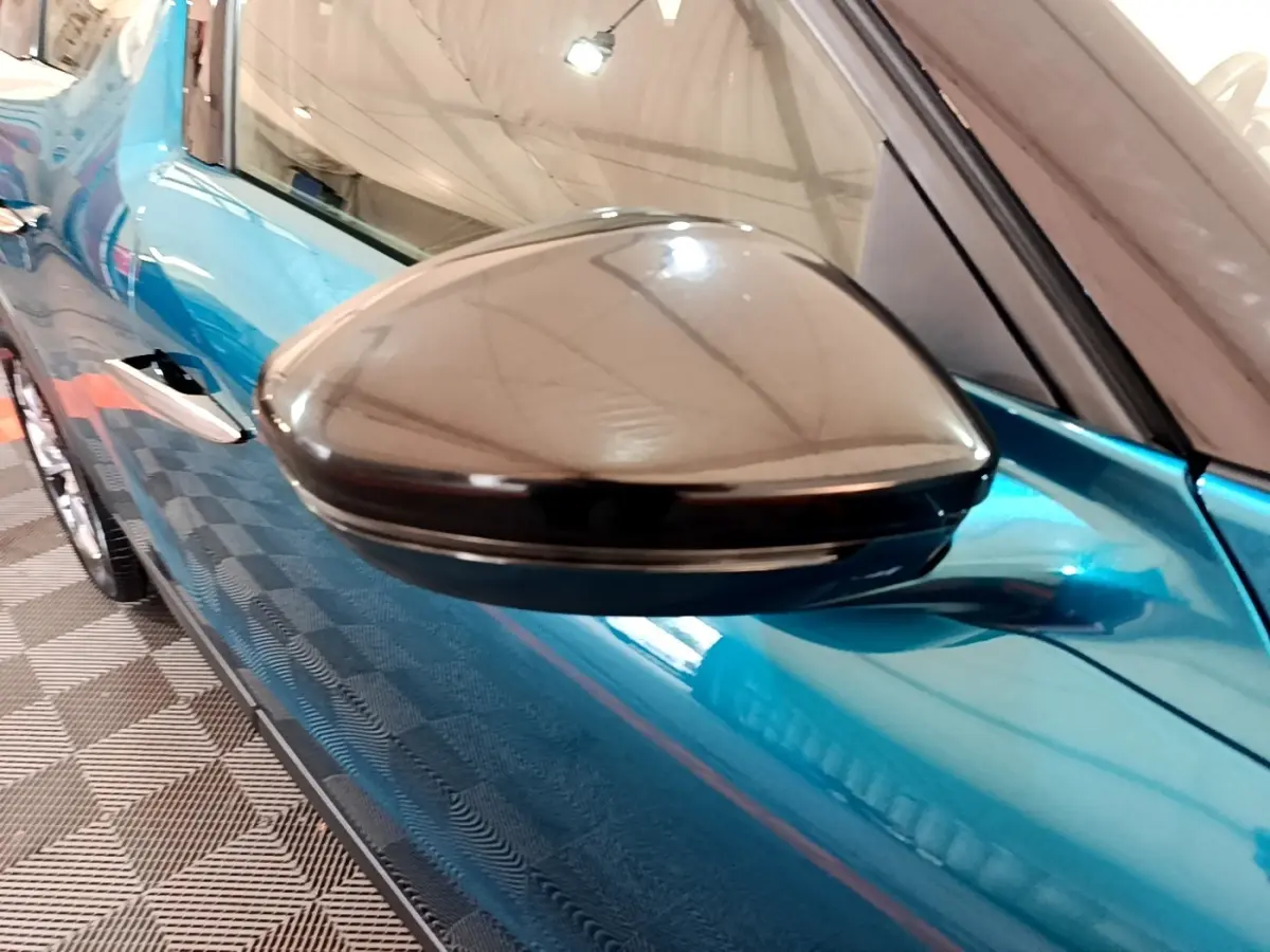 Rétroviseur noir brillant en gros plan côté gauche sur la portière bleu vif d'un DS3 Crossback 2020.