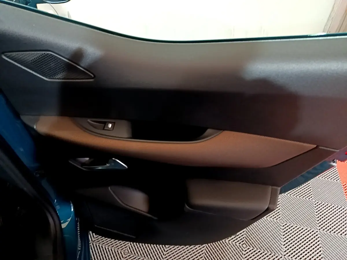 Vue rapprochée de la porte avant gauche du DS3 Crossback bleu, montrant la poignée et les commandes de fenêtre.