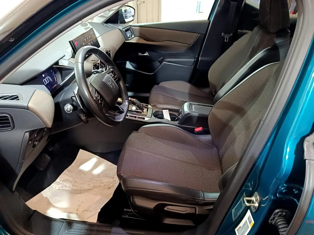 Intérieur du DS3 Crossback bleu, vue côté conducteur, sièges tissu marron et tableau de bord moderne avec écran tactile.