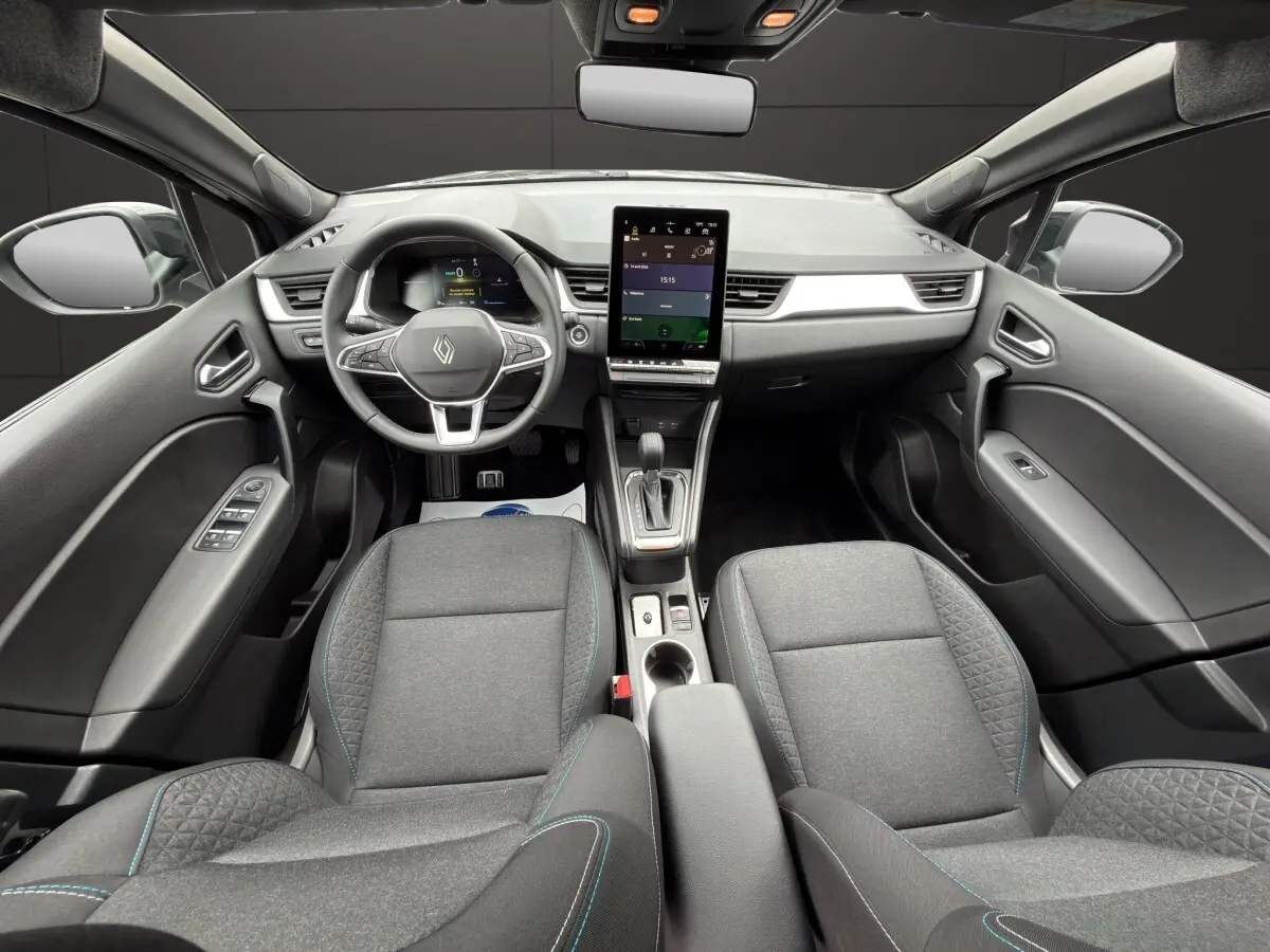 Vue intérieure avant du Renault SYMBIOZ noir, mettant en valeur le volant multifonctions et l'écran tactile central vertical.