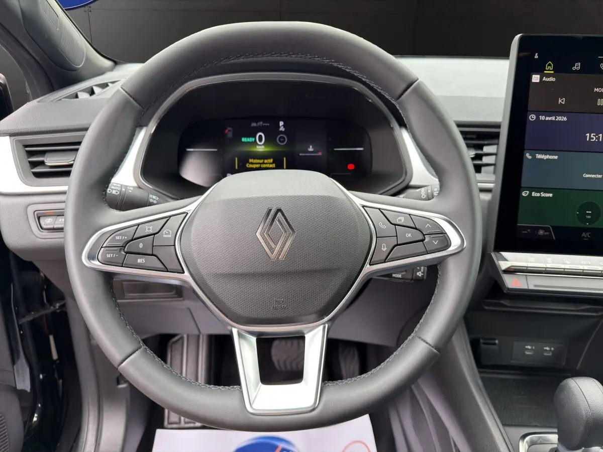 Vue rapprochée du volant noir de la Renault SYMBIOZ 2025 avec commandes multifonctions et écran tactile central visible.