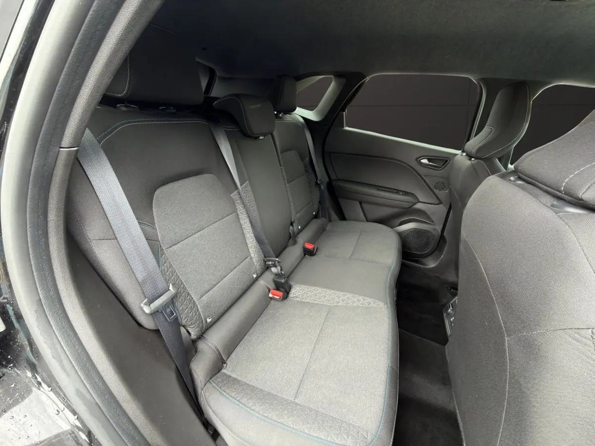 Vue intérieure côté droit sur la banquette arrière noire du Renault SYMBIOZ 2025 avec ceintures et appuie-têtes intégrés.