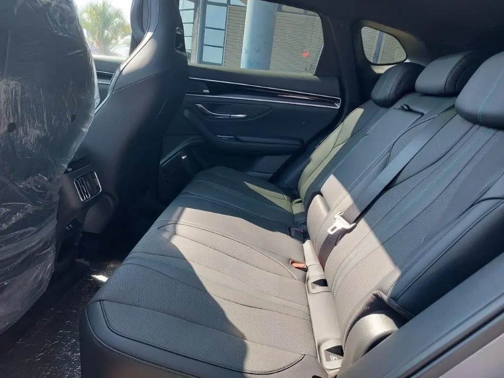 Vue intérieure côté droit des sièges arrière en cuir gris foncé du BYD SEAL U DM-i BOOST 2026, avec appuie-têtes et ceintures de sécurité.