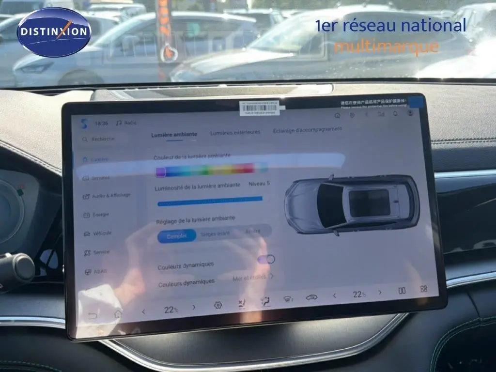 Vue intérieure centrée sur l'écran tactile du tableau de bord du BYD SEAL U gris, affichant les réglages de lumière ambiante.