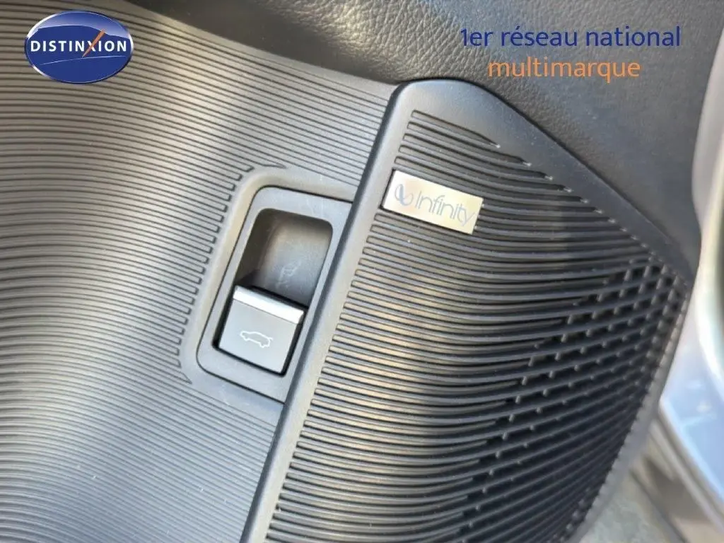 Gros plan sur le bouton d'ouverture du coffre et haut-parleur Infinity intégré dans le panneau intérieur côté conducteur du BYD SEAL U.