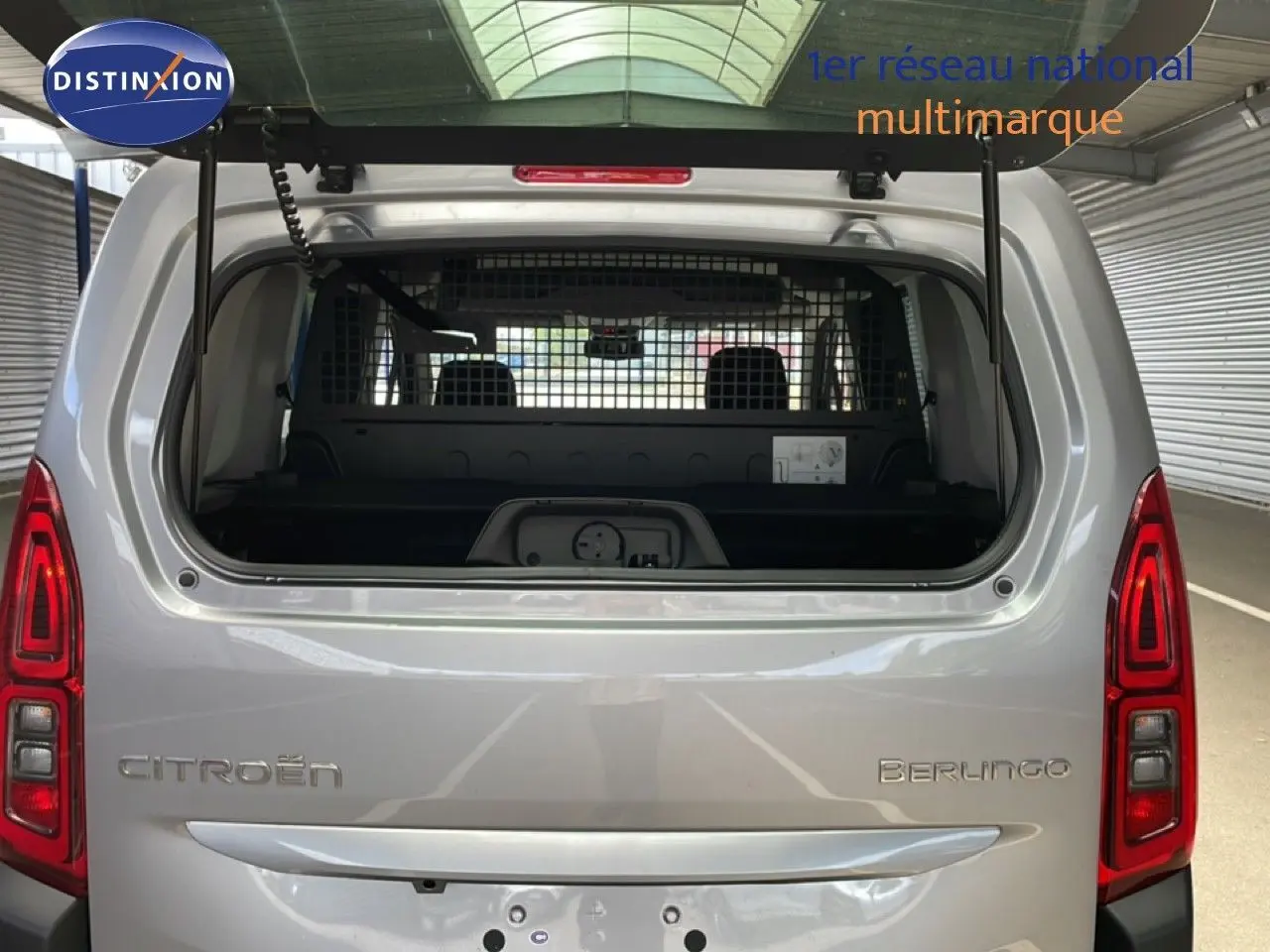 Vue arrière du Citroën Berlingo gris Artense métal 2026 avec hayon ouvert et séparation intérieure visible.