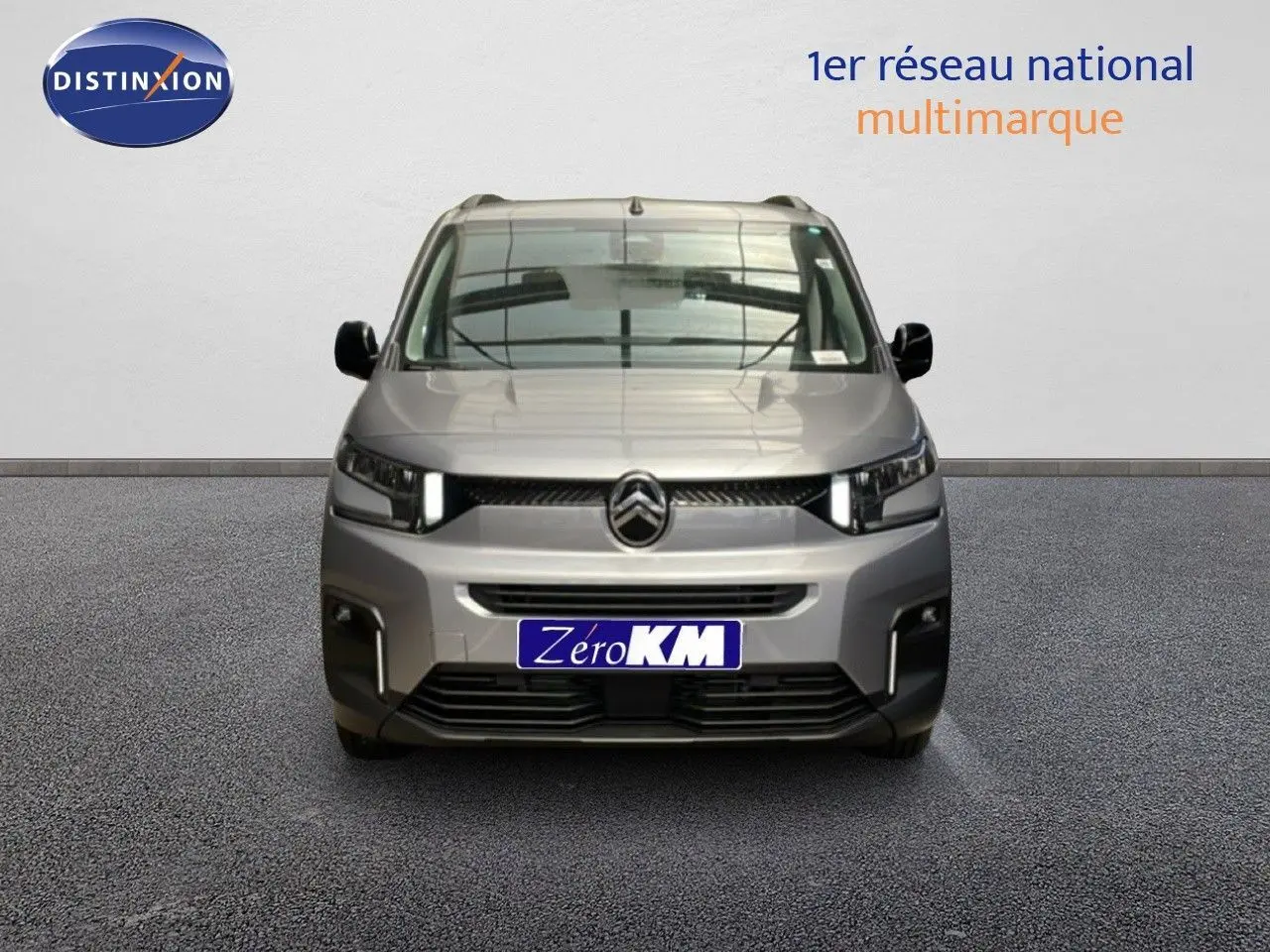 Vue frontale d'un Citroën Berlingo gris Artense métal 2026 avec calandre noire et phares LED allumés.