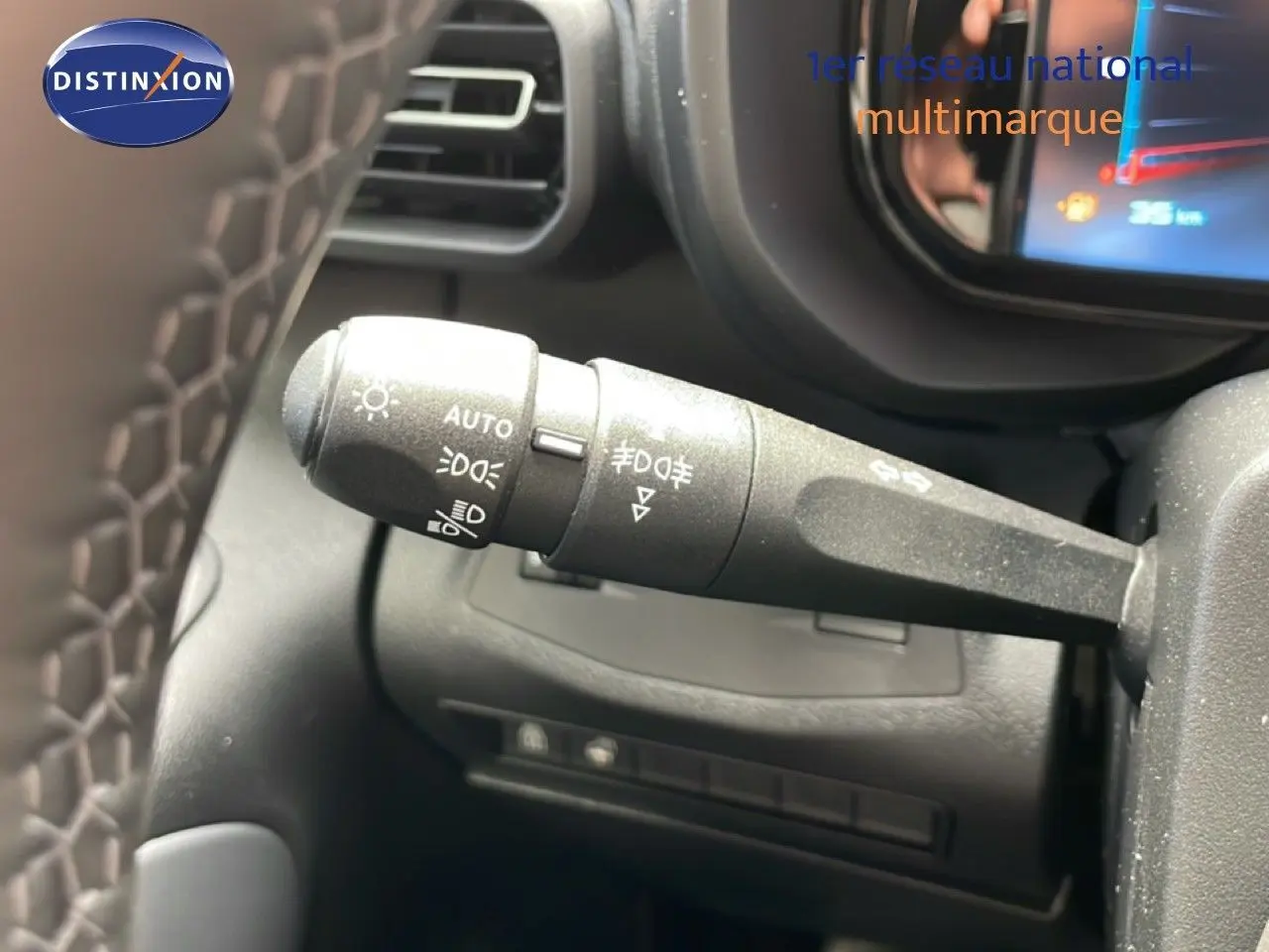 Gros plan sur la commande des feux à gauche du volant dans l’habitacle gris du Citroën Berlingo 2026.