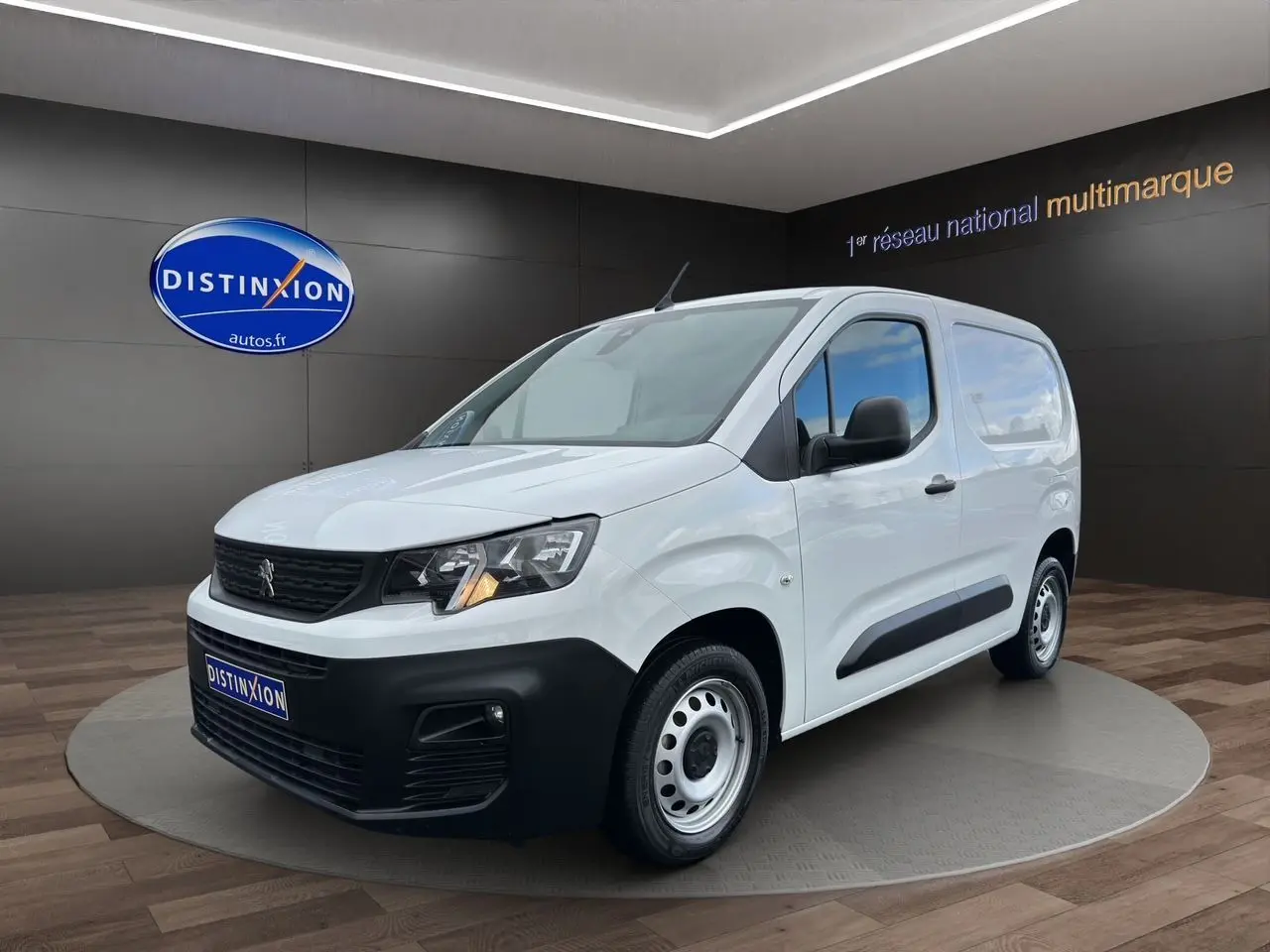 Vue 3/4 avant droite d'un Peugeot Partner blanc 2022 avec pare-chocs noir et jantes acier simples.