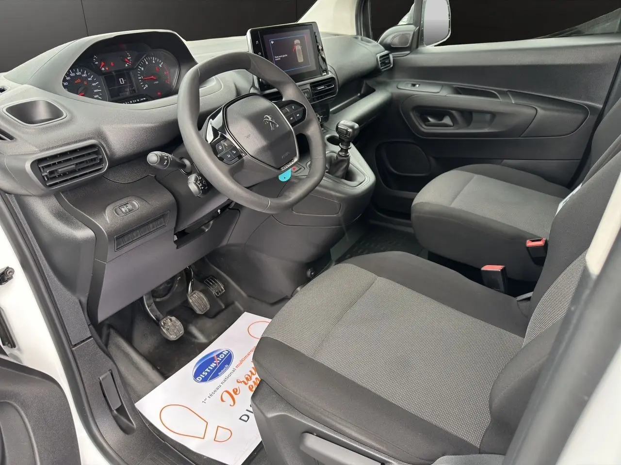 Intérieur avant droit du Peugeot Partner blanc 2022, avec tableau de bord moderne et écran tactile central.