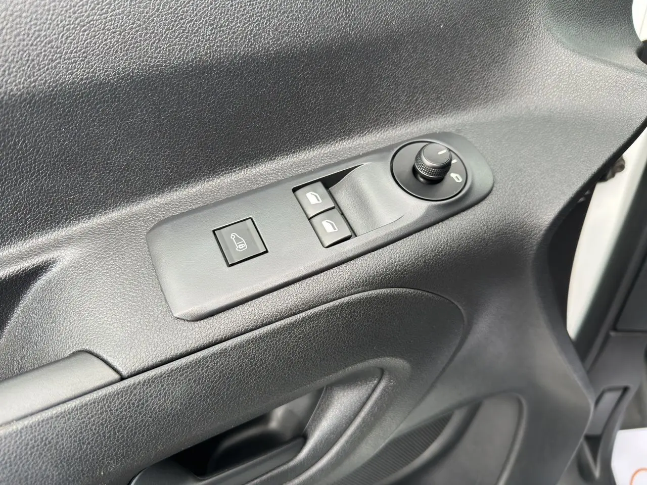 Gros plan sur la commande de réglage des rétroviseurs et vitres côté conducteur d'un Peugeot Partner blanc 2022.