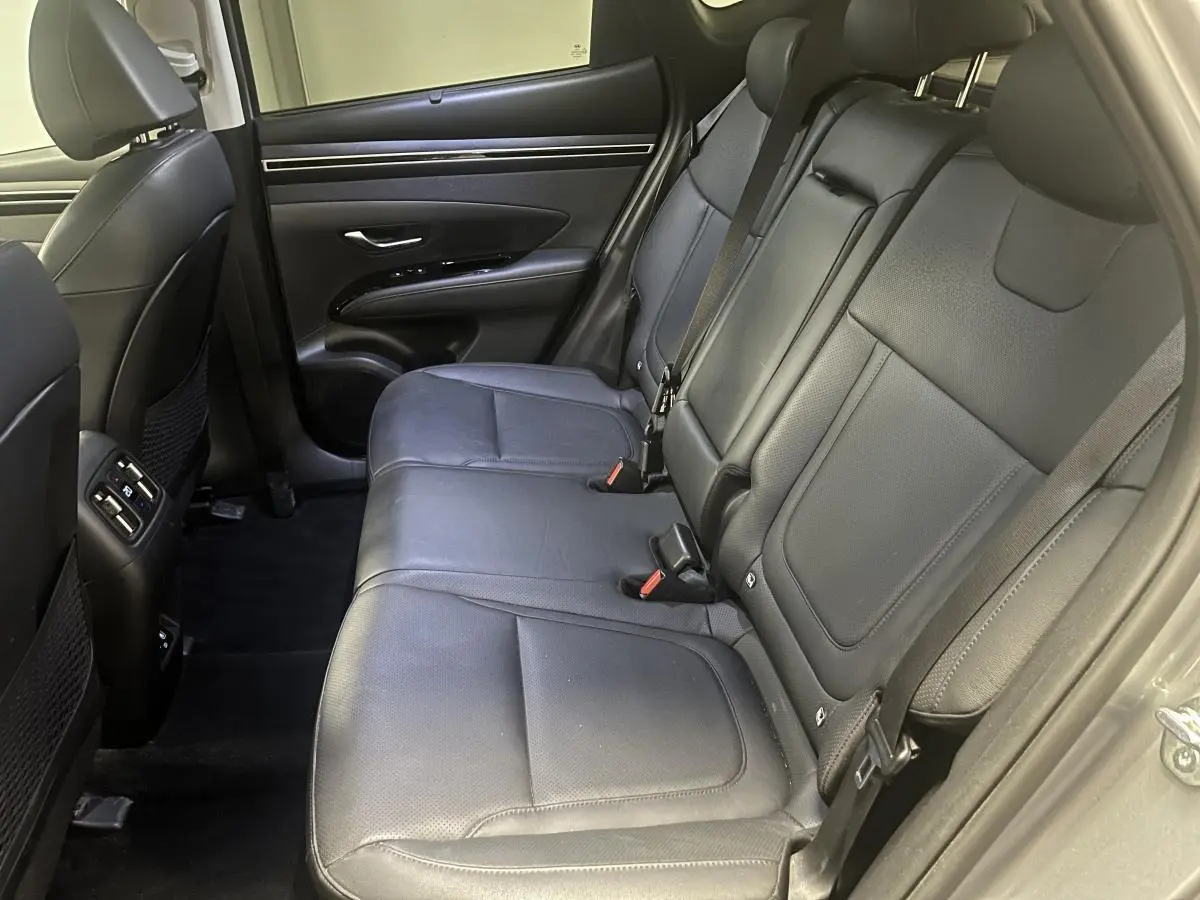 Vue latérale droite des sièges arrière en cuir noir du Hyundai Tucson 2023, soulignant l'espace et les ceintures de sécurité.