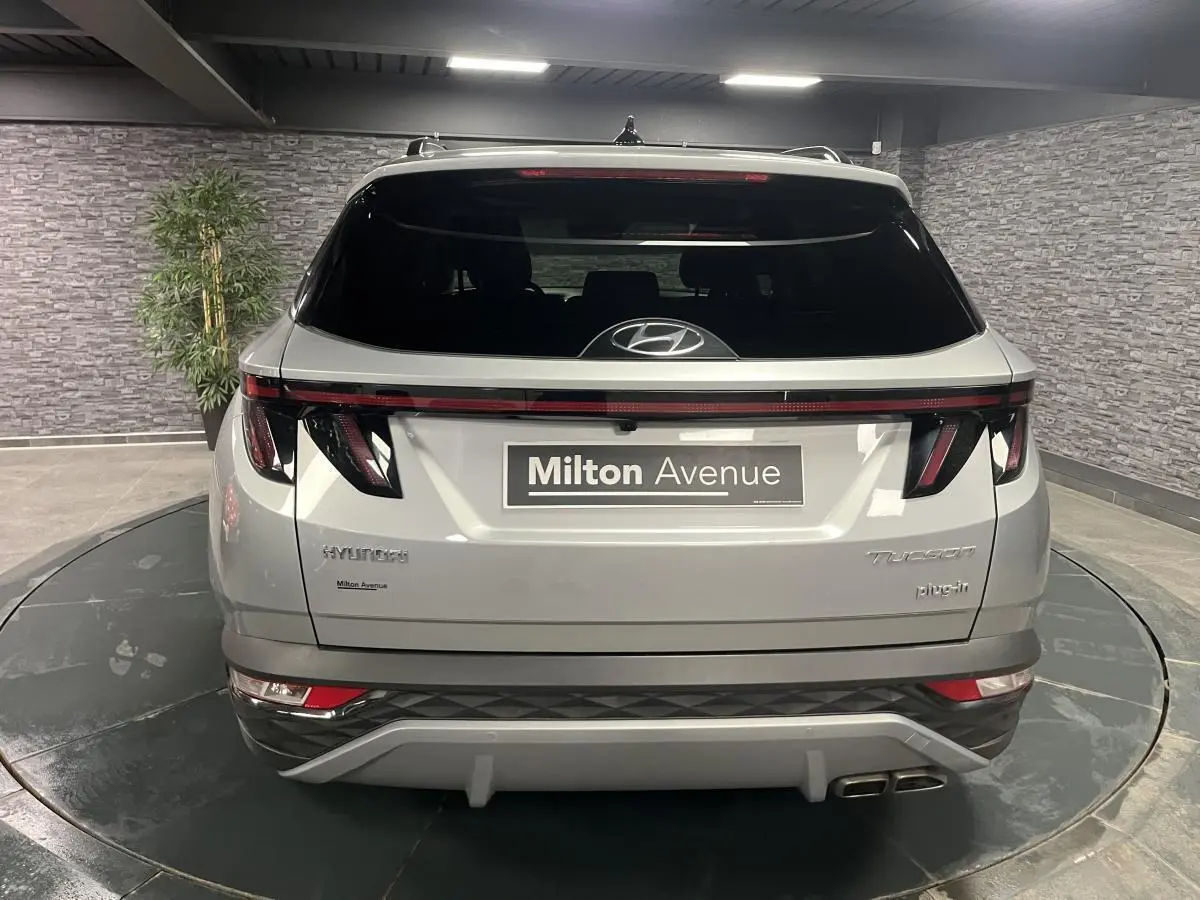 Vue arrière du Hyundai Tucson gris métallisé 2023 avec feux LED reliés et double sortie d’échappement visible.
