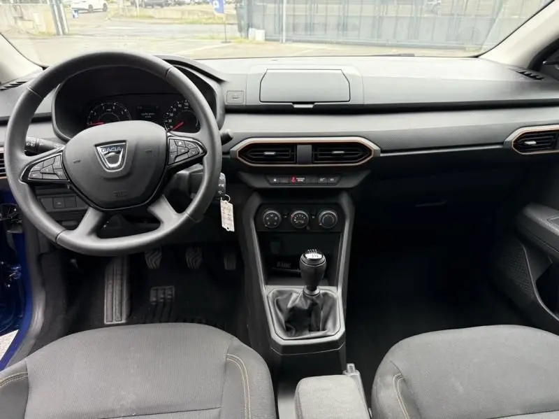 Vue intérieure avant du tableau de bord et volant noir de la Dacia Sandero Stepway 2022 bleu métal avec boîte manuelle.