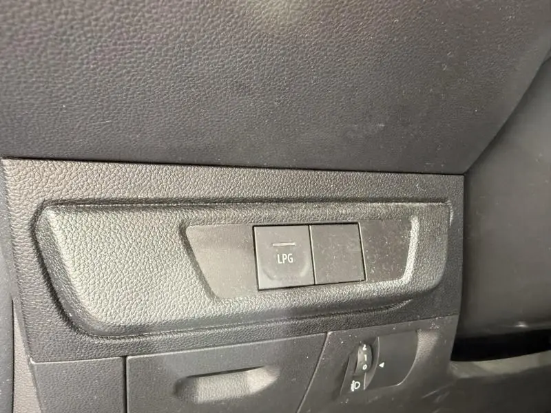 Bouton de commande LPG en gros plan sur le tableau de bord noir d'une Dacia Sandero Stepway bleu métal 2022.