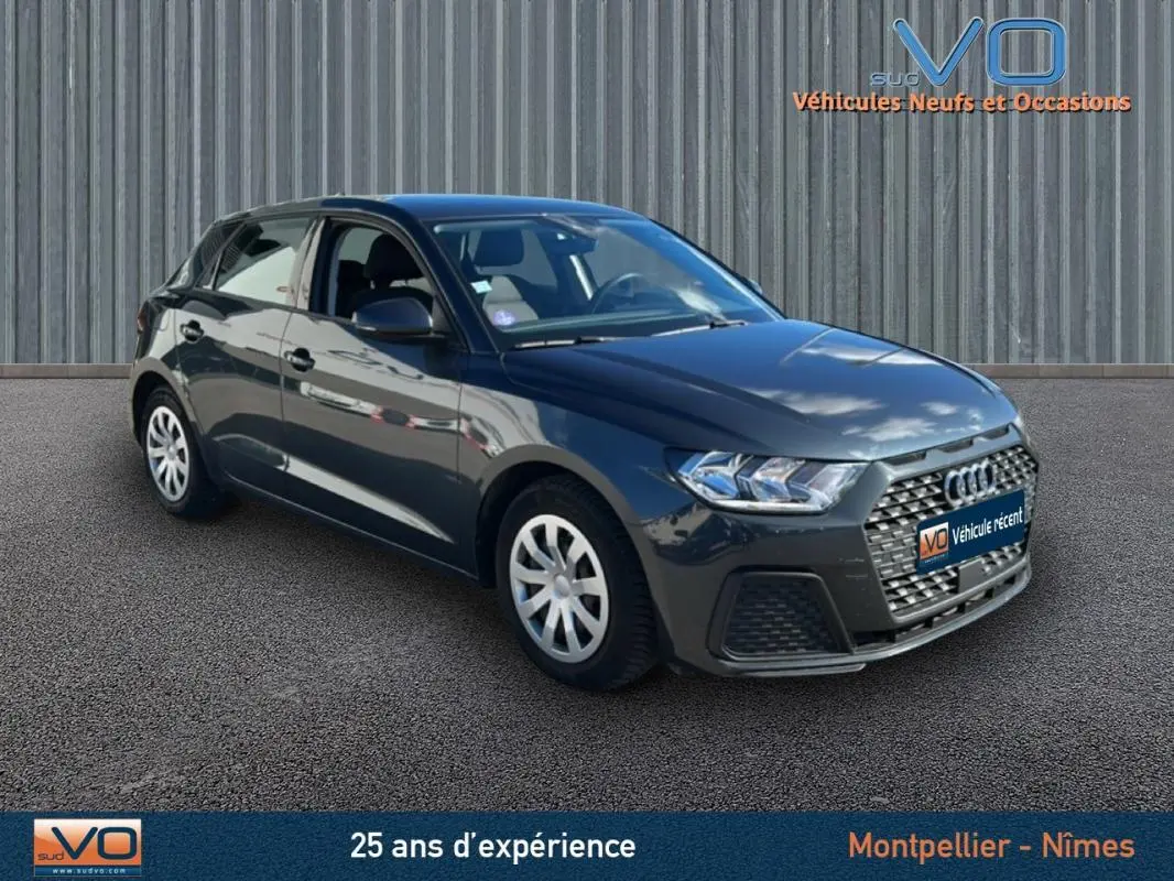 Audi A1 Sportback gris foncé vue 3/4 avant droit, avec calandre hexagonale et phares LED distinctifs.