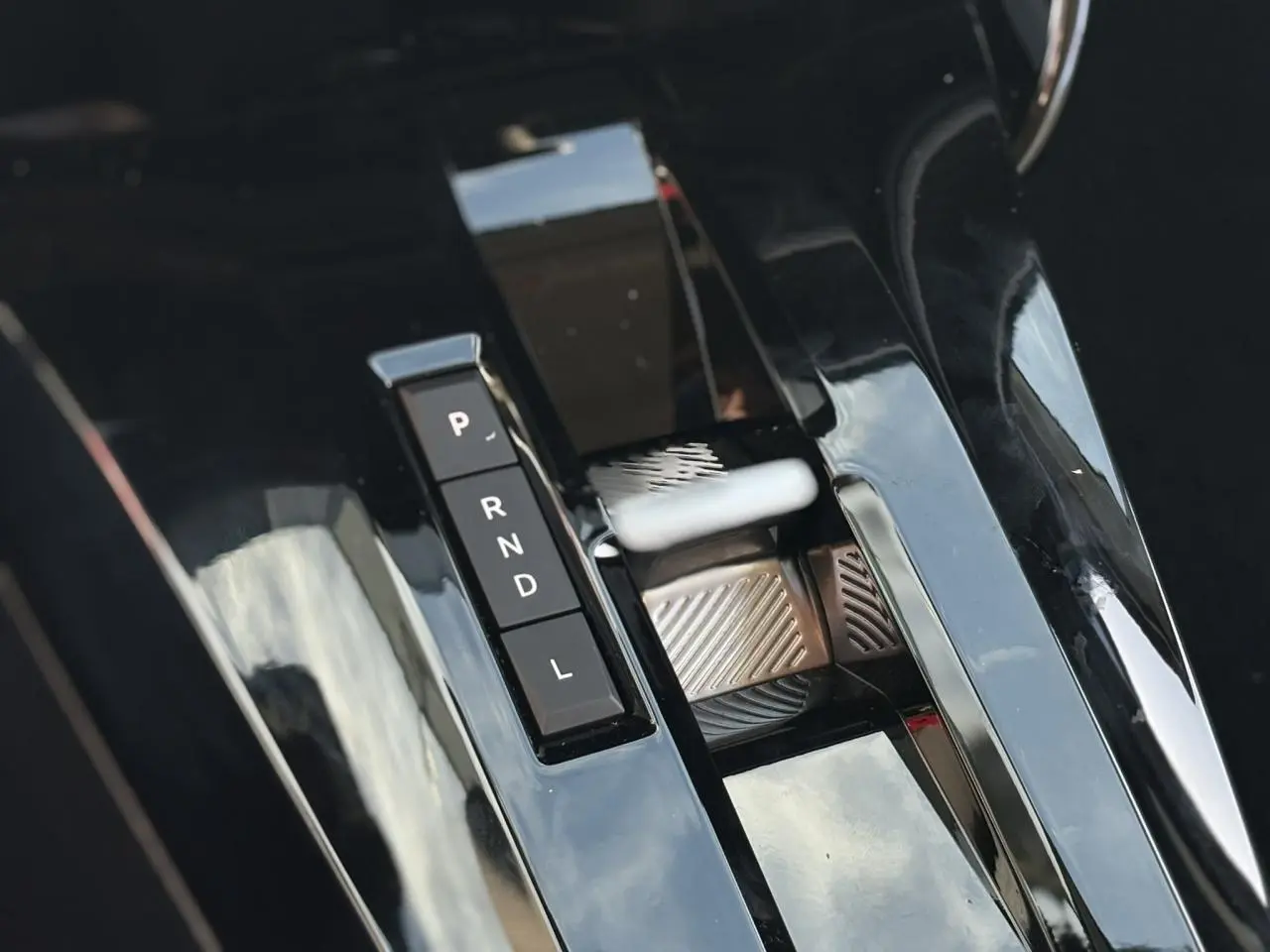 Gros plan sur la commande de boîte automatique noire brillante du Citroën C3 Aircross Hybrid 145, détails des boutons P, R, N, D, L.