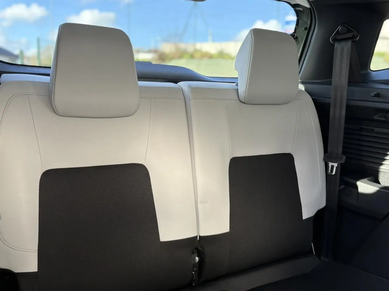 Vue rapprochée de la banquette arrière 2 places bicolore beige et noir du Citroën C3 Aircross Hybrid 2025.