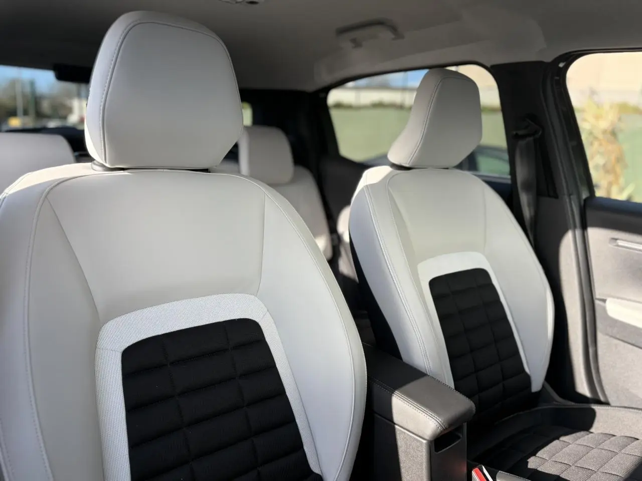 Vue intérieure rapprochée des sièges avant en cuir blanc et tissu noir du Citroën C3 Aircross 2025.