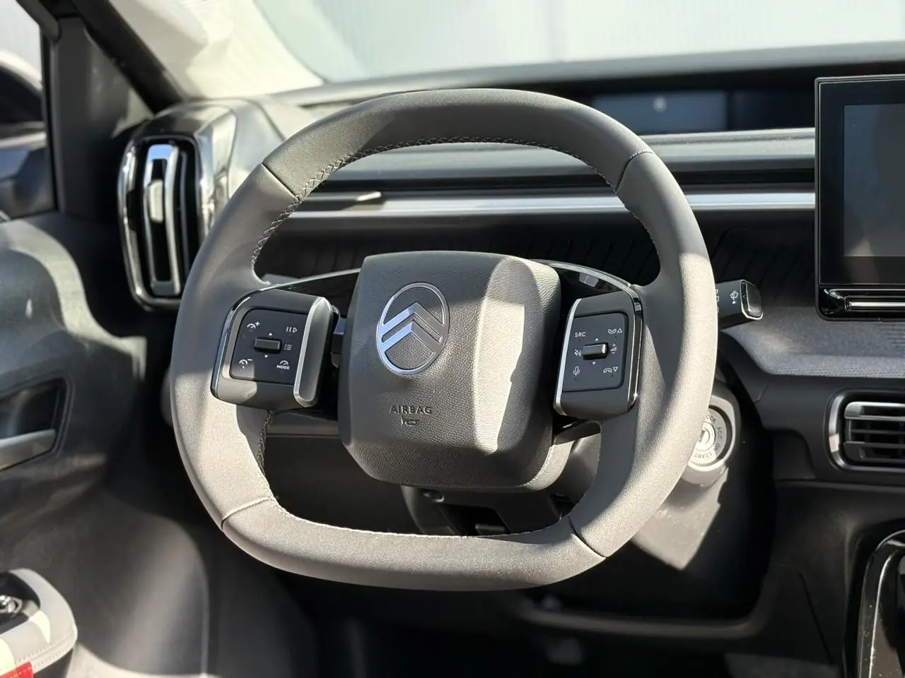 Volant multifonctions noir de Citroën C3 Aircross 2025 vu de face, avec tableau de bord gris et écran tactile à droite.