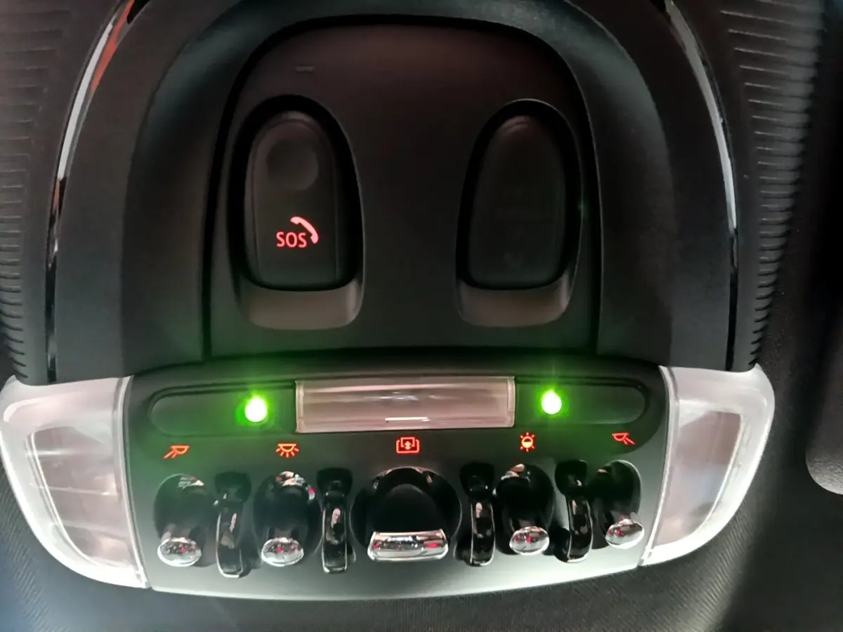 Gros plan sur les commandes de plafonnier et bouton SOS du MINI Countryman Cooper SE bleu, intérieur noir.