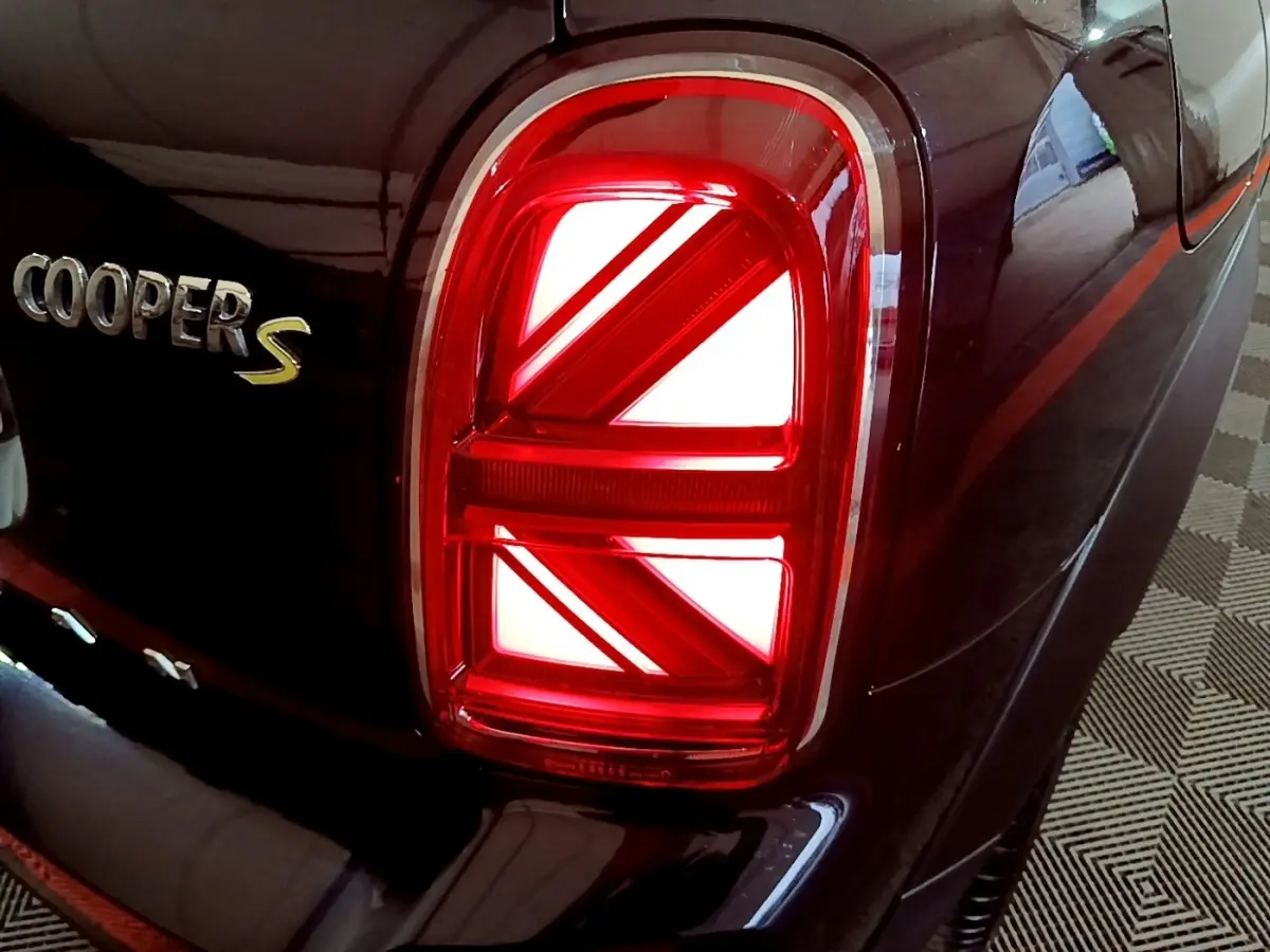 Gros plan sur le feu arrière droit rouge et le logo Cooper S sur la carrosserie bleu foncé d'une MINI Countryman.
