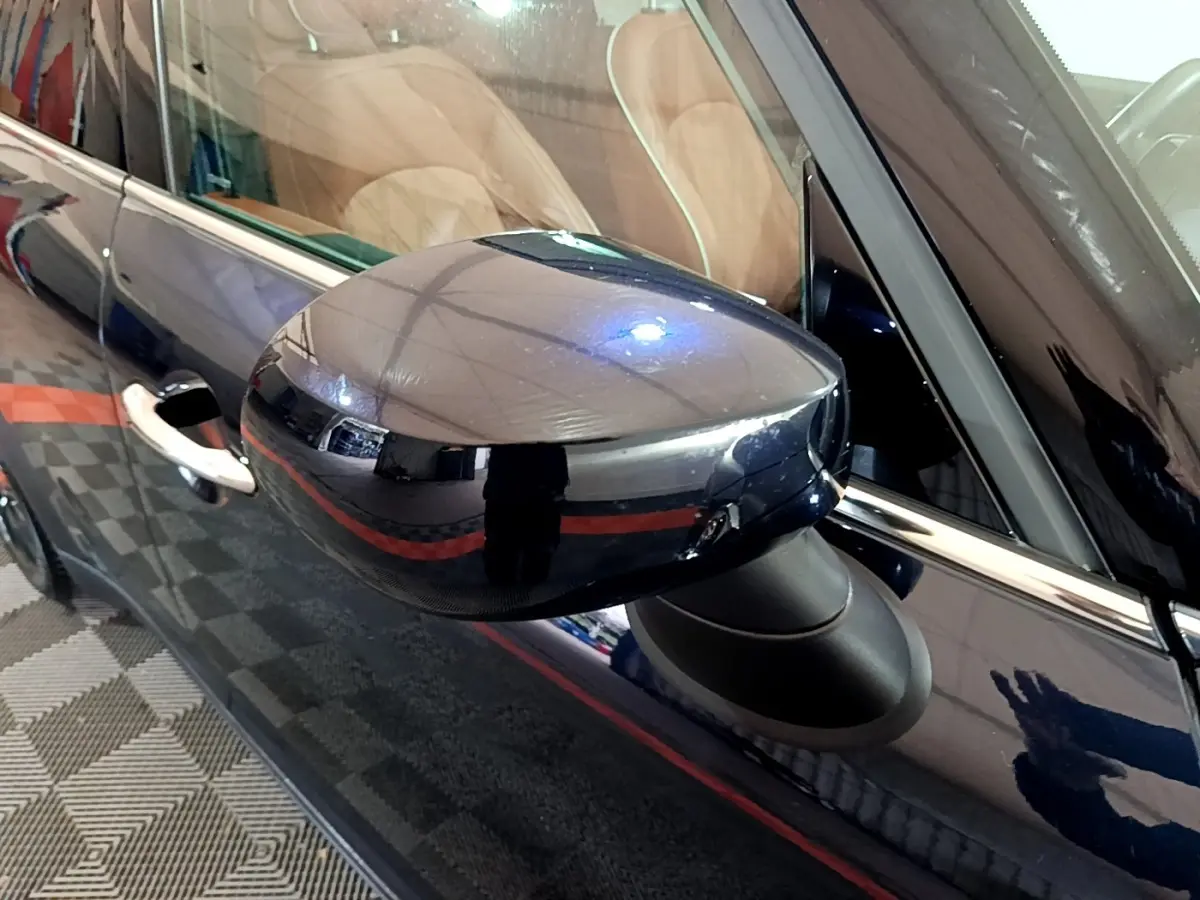 Rétroviseur côté gauche bleu brillant d'une MINI Countryman Cooper SE 2021 avec poignée de porte visible.