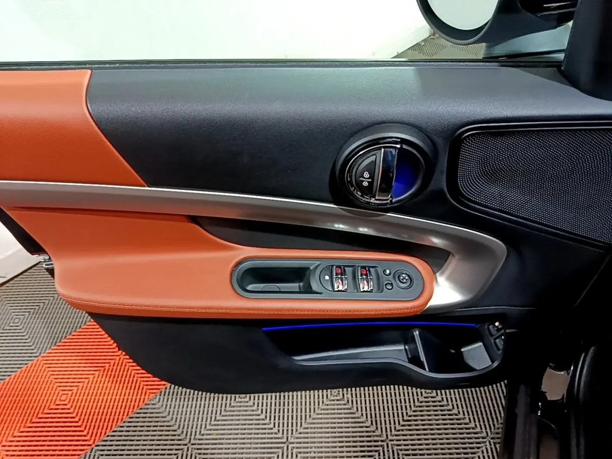 Intérieur côté gauche de porte MINI Countryman avec garniture cuir marron et commandes électriques des vitres.