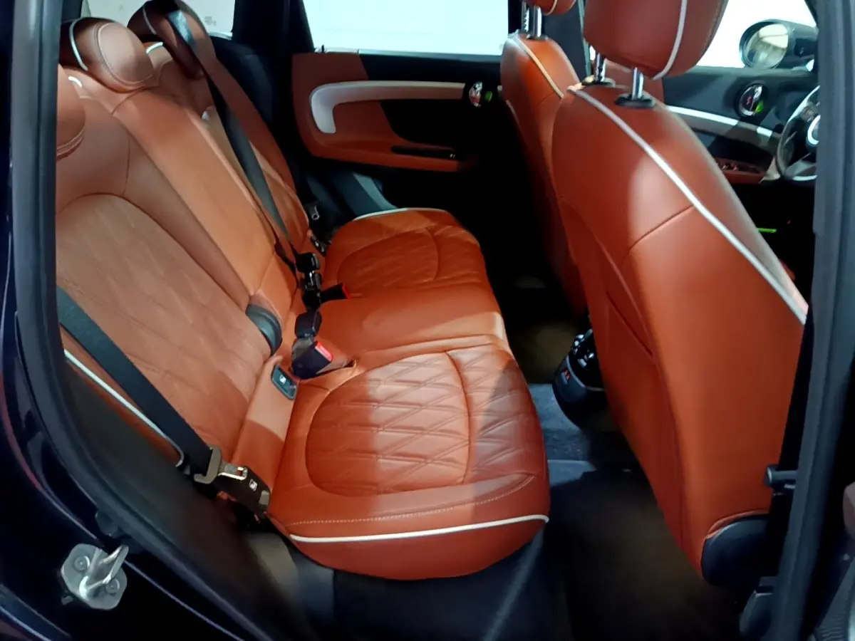 Vue intérieure côté gauche sur les sièges arrière en cuir marron du MINI Countryman Cooper SE 2021.