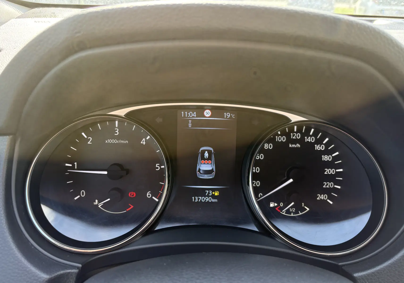 Vue rapprochée du tableau de bord du Nissan X-TRAIL 2016, affichant compte-tours, vitesse et écran central digital.