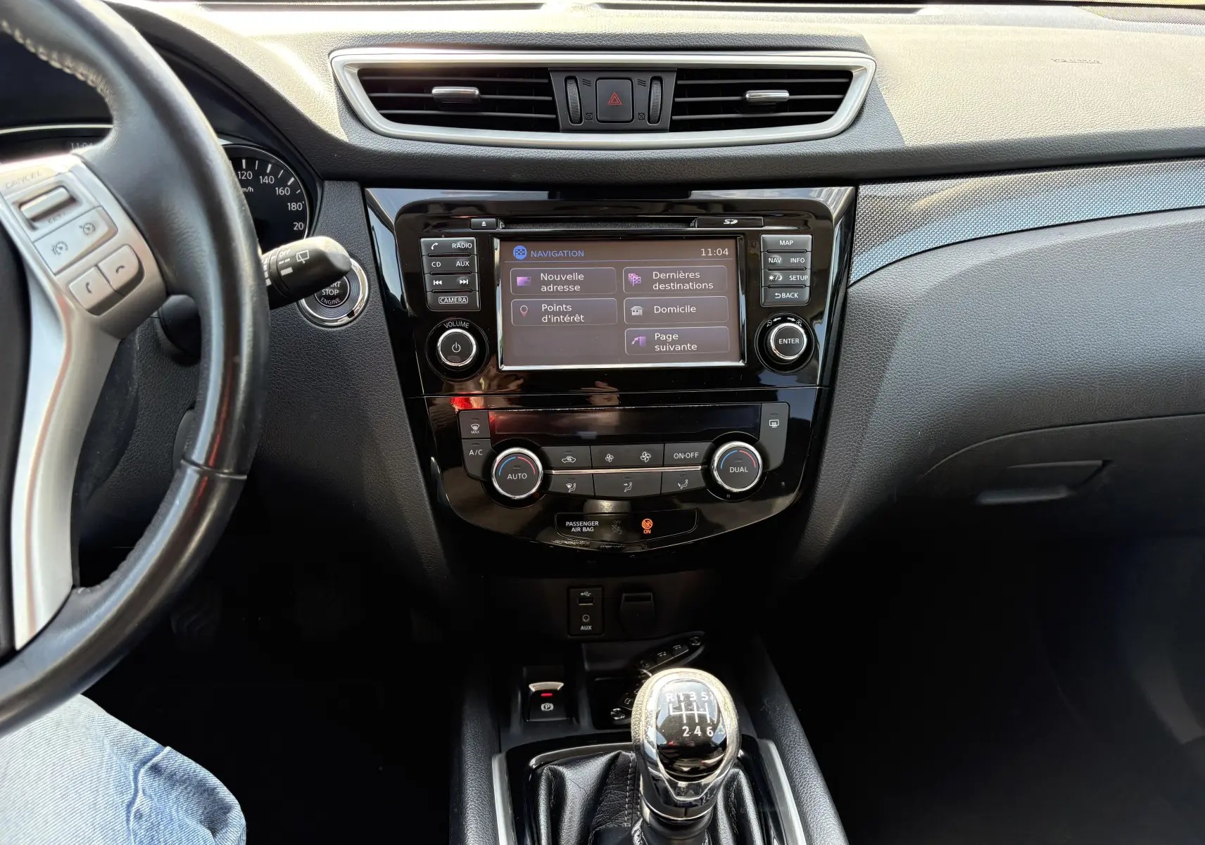 Vue intérieure centrée sur la console centrale et levier de vitesse manuel du Nissan X-TRAIL 2016, finition White Edition.