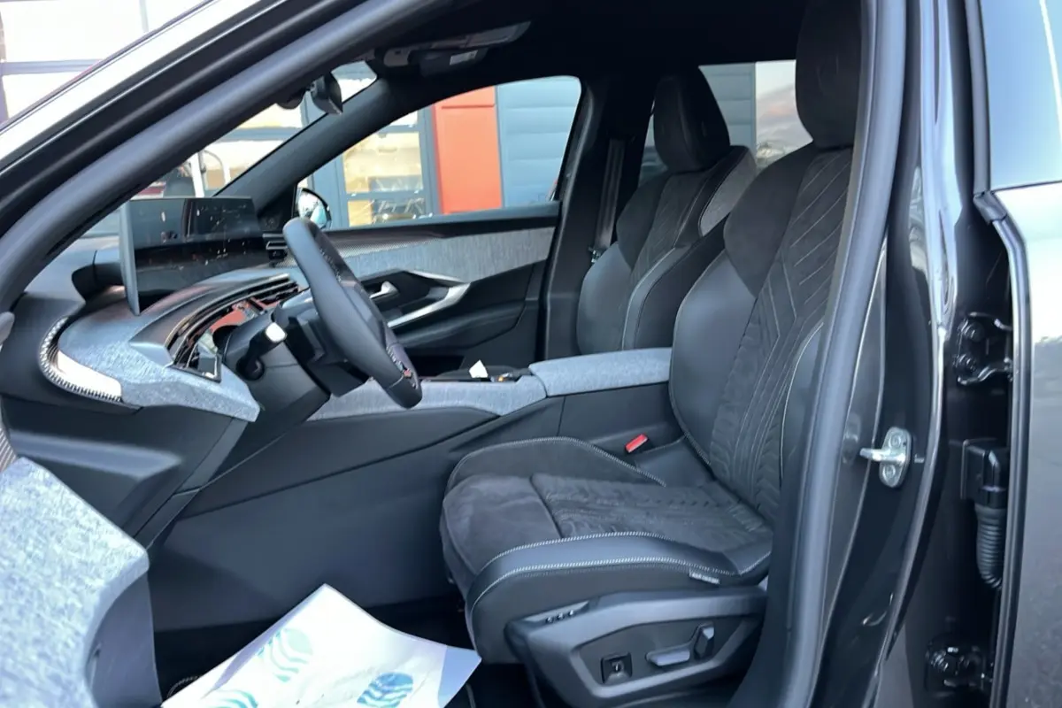 Vue intérieure côté conducteur du Peugeot 5008 Hybrid 145 GT avec sellerie Alcantara gris et tableau de bord moderne.