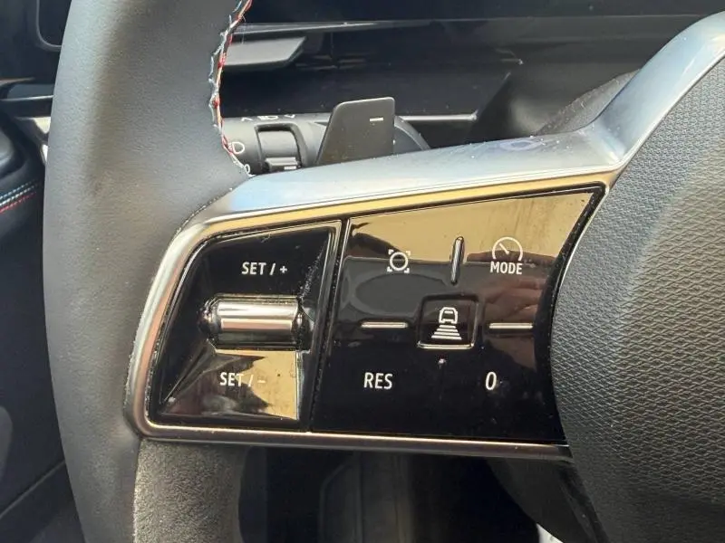 Gros plan sur les commandes de régulateur de vitesse au volant du Renault Rafale noir étoilé, finition esprit Alpine.