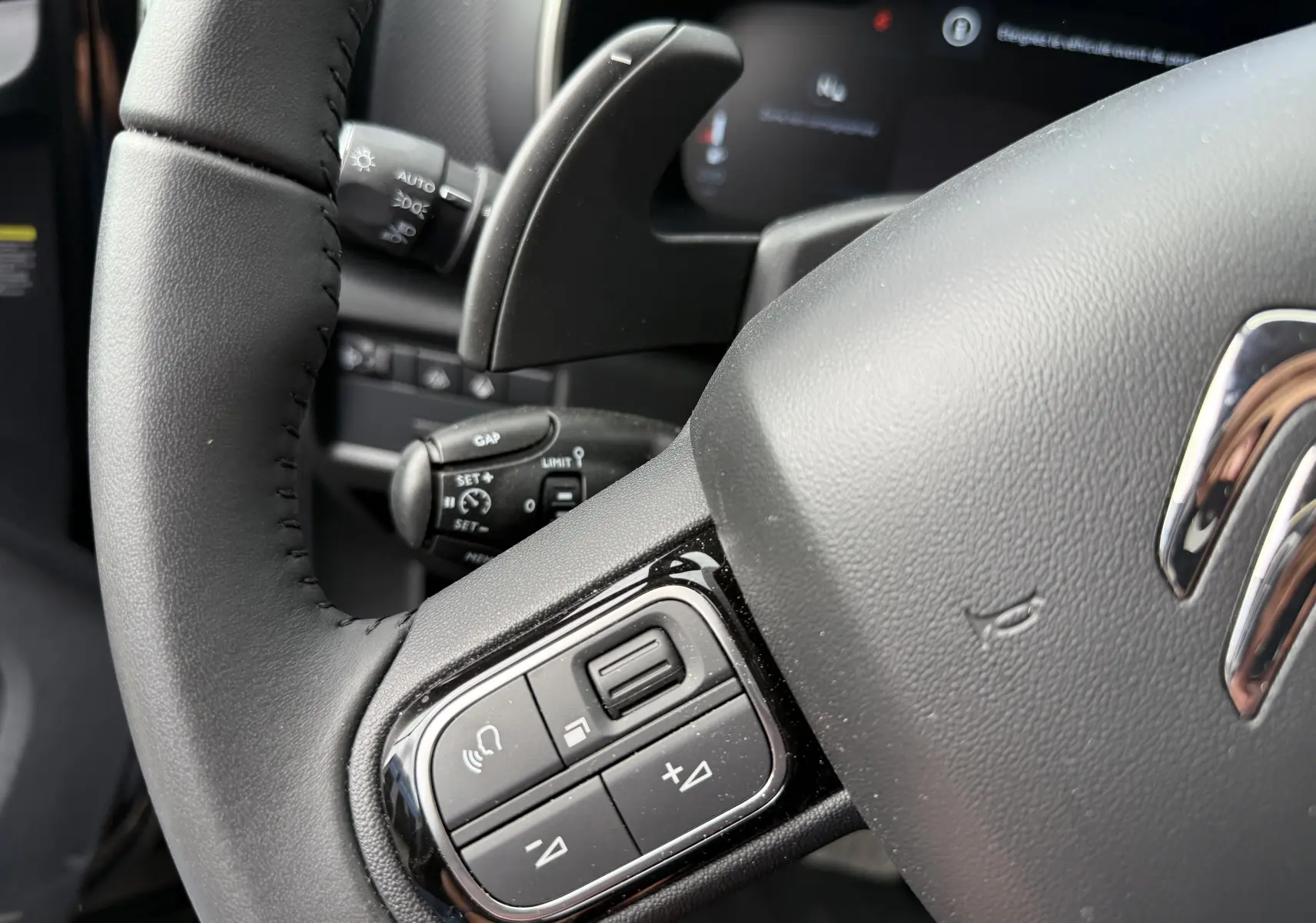 Vue rapprochée du volant noir du Citroën C5 Aircross 1.5 HDi 130, avec commandes intégrées et tableau de bord numérique.