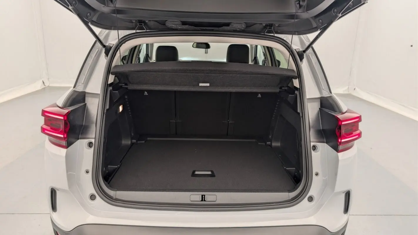 Coffre ouvert vu de l'arrière d'un Citroën C5 Aircross blanc Okenite 2025, avec banquette arrière visible.